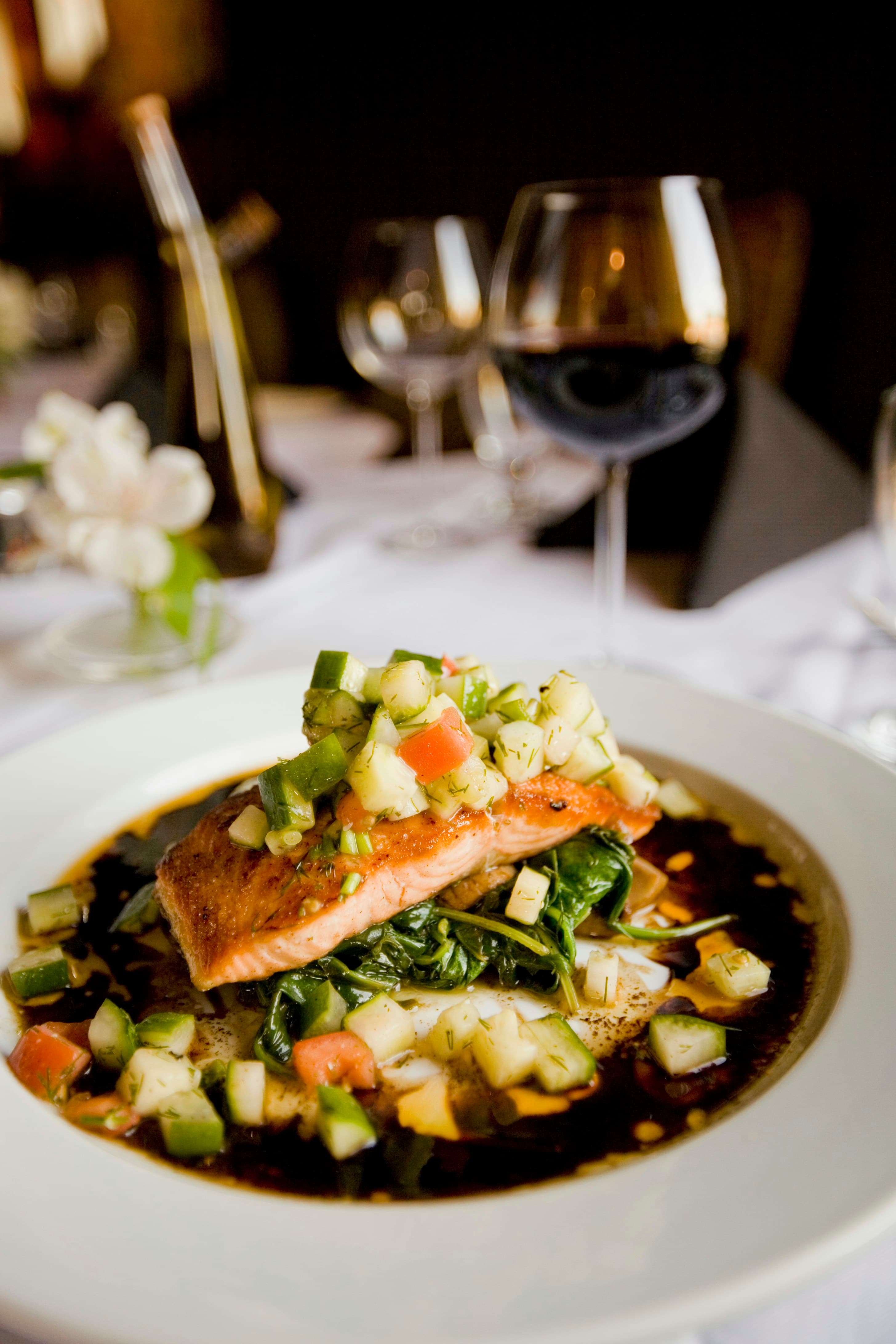 A plated fish fillet with vegetables in broth
